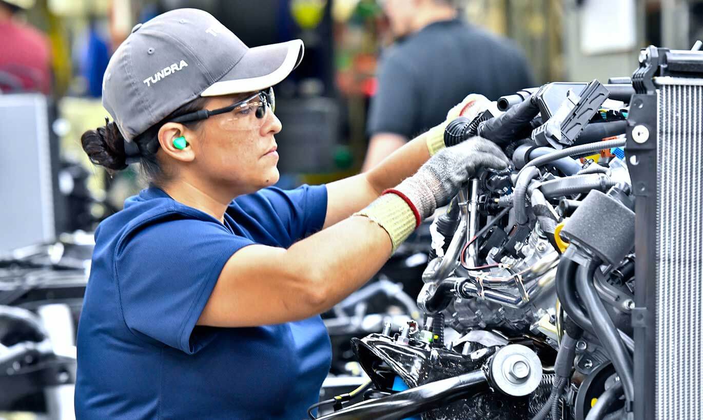 A woman assembles an engine in the Toyota factory