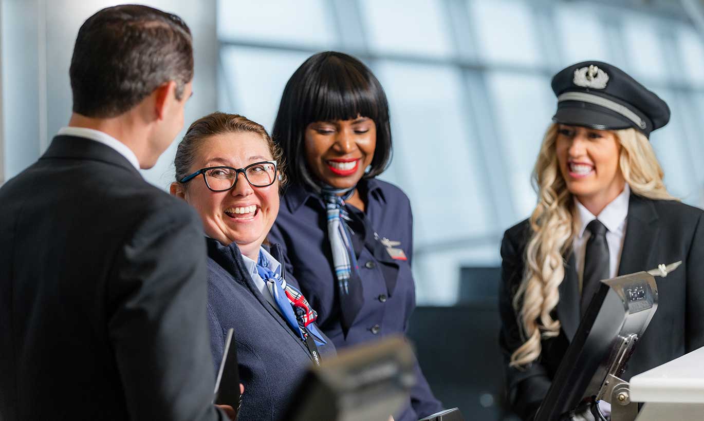 A group of flight attnedants for American Airlines gather togetether to check-in guests