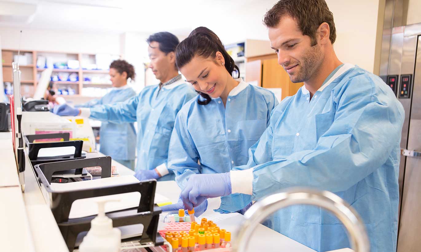 A team of lab technicians look at vials together in Houston, Texas