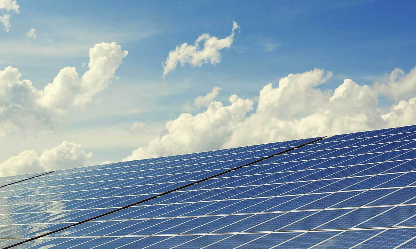 Solar power pannels are lit up under a sunny sky