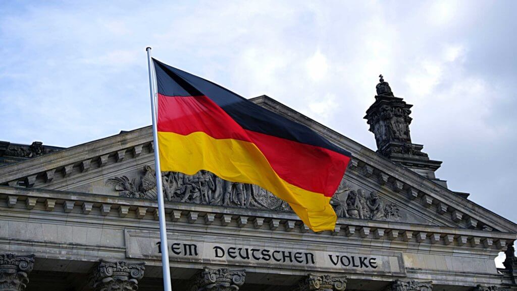 The German flag flies in front of the Dem Deutschen Volke building