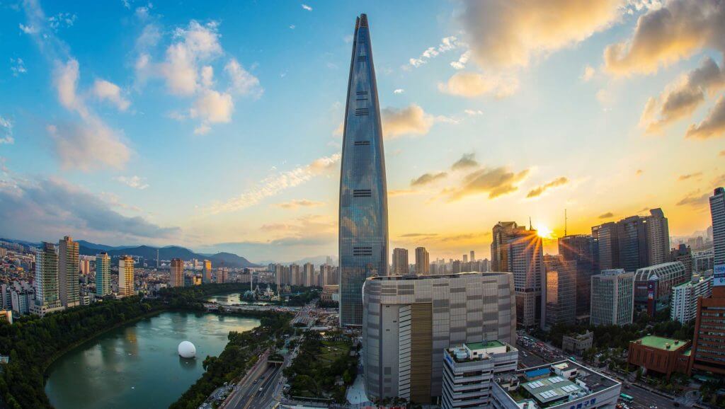 Tall glass buildings reflect a setting sun in Seoul, South Korea