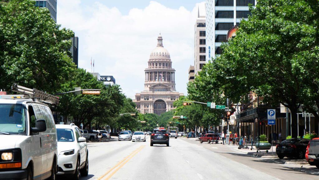 A busy street approaches the Texas Capital building in Austin, Texas.