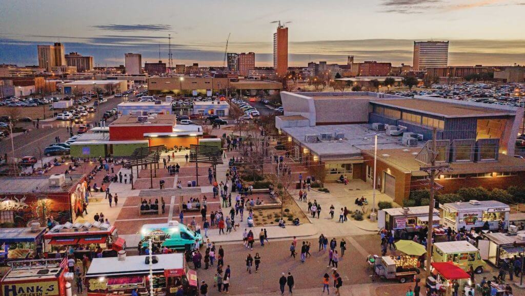 Residents of Lubbock, Texas stroll through the First Friday fair with food trucks