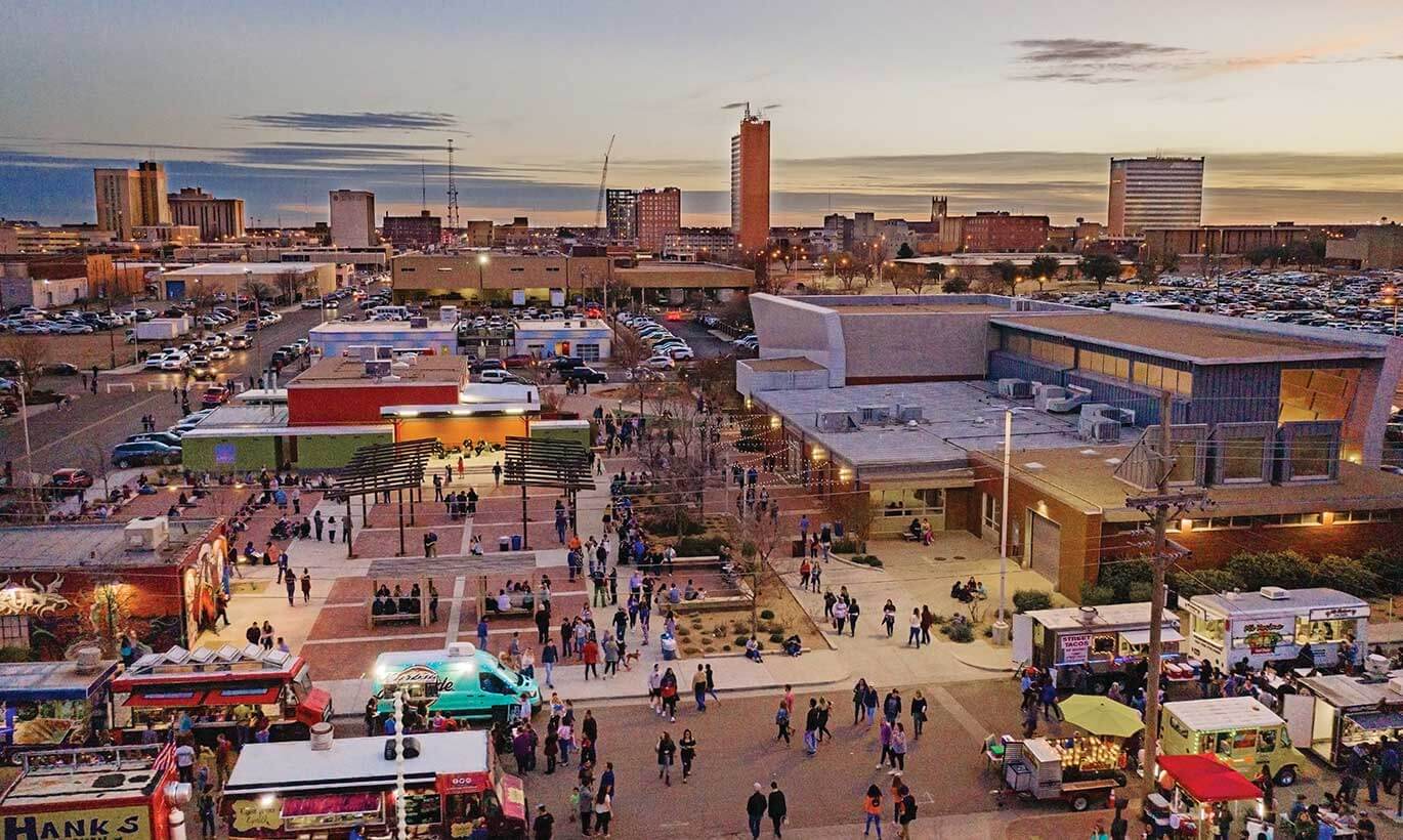 Residents of Lubbock, Texas stroll through the First Friday fair in a central town plaza area