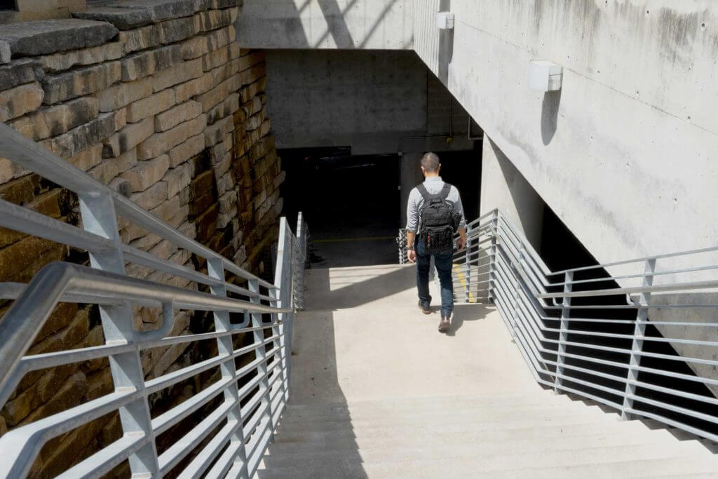 A man with a backpack walks downstairs in Austin, Texas.