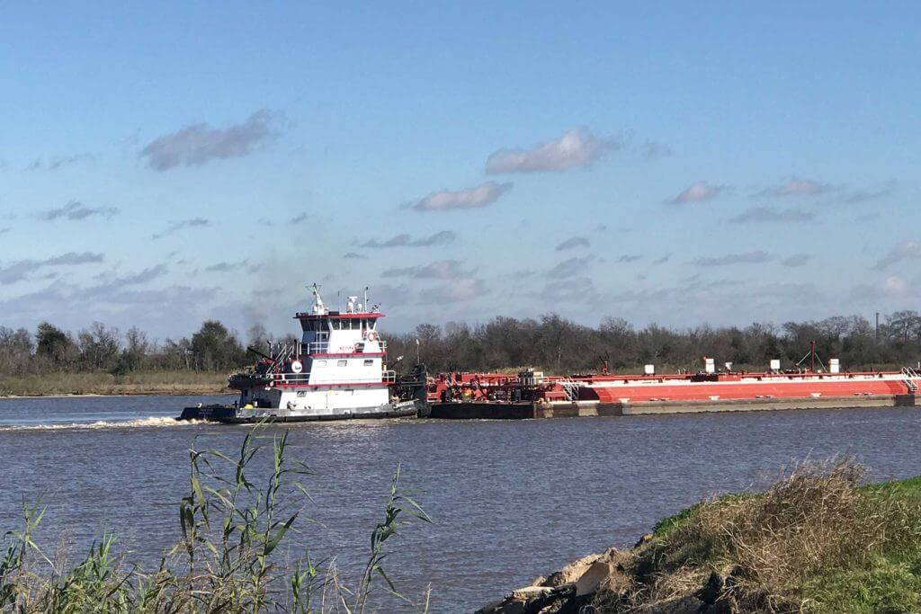 A large cargo ship floats down the river at Port Arthur, Texas.