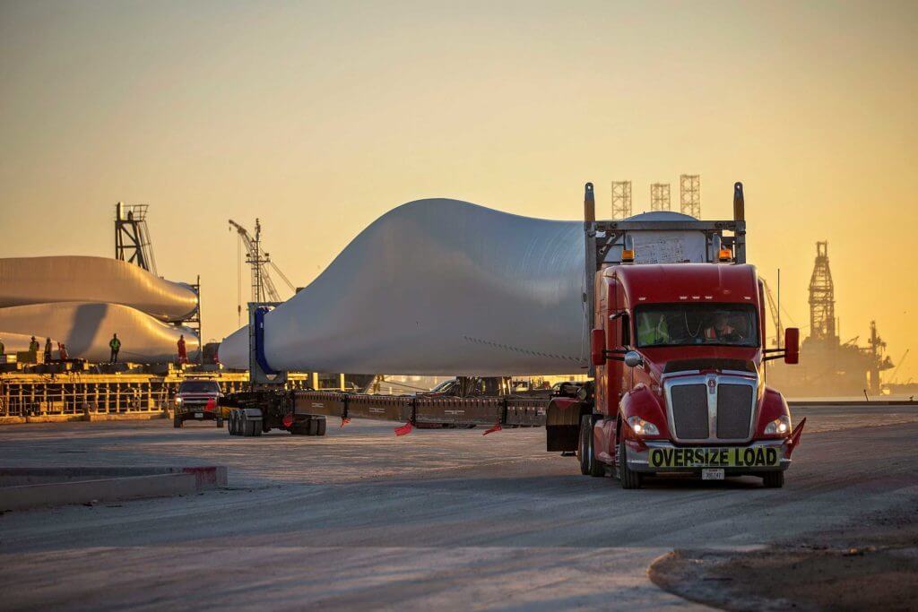 A large truck transports a metal windmill propellor at the Port of Brownsville, Texas.