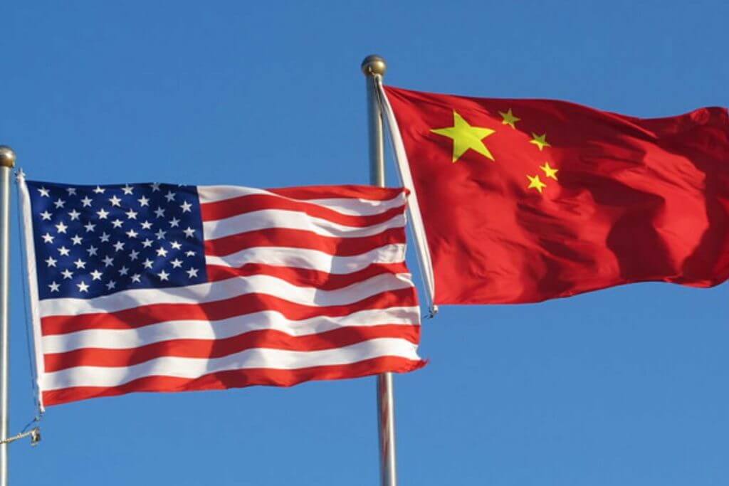 The Chinese flag and US flag flying in the sky next to each other