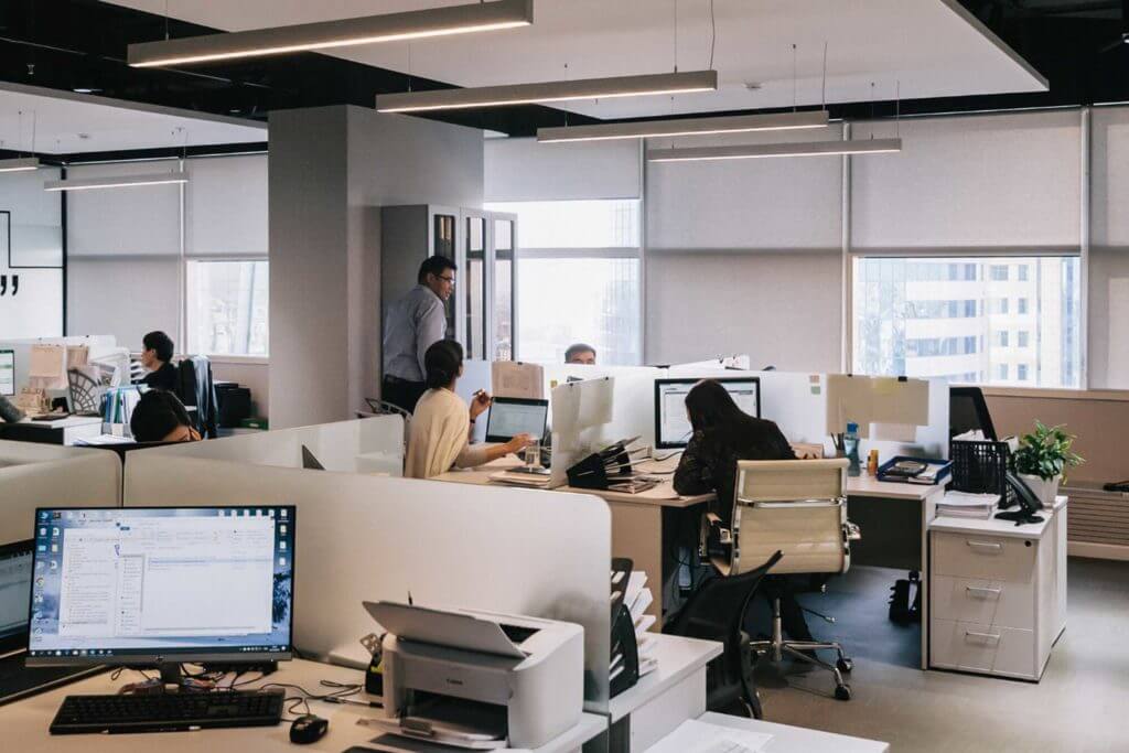 Workers sit at their computers inside an office building