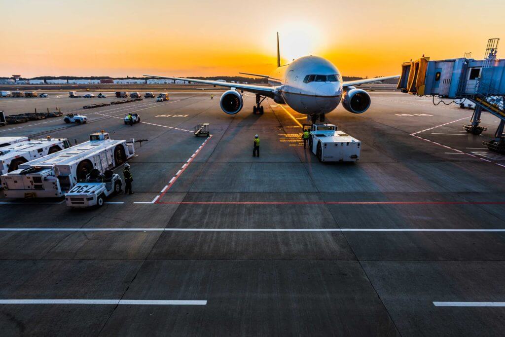 An airplane sits on the jetpad at sunset