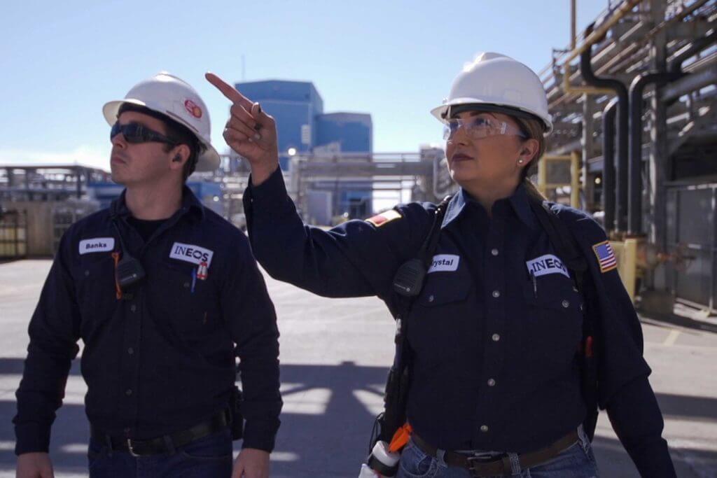 A man and a woman wearing hard hats work in the petrochemical field at INEOS.