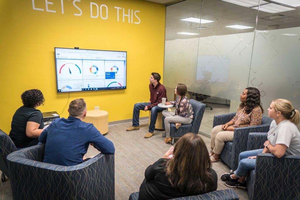 A group of employees sits down in a conference room for a meeting in Temple, Texas.