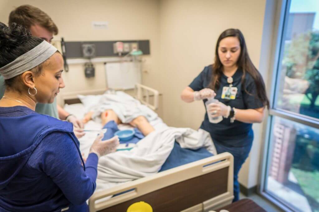 Nursing students learn from an instructor in a clinical setting in Temple, Texas.
