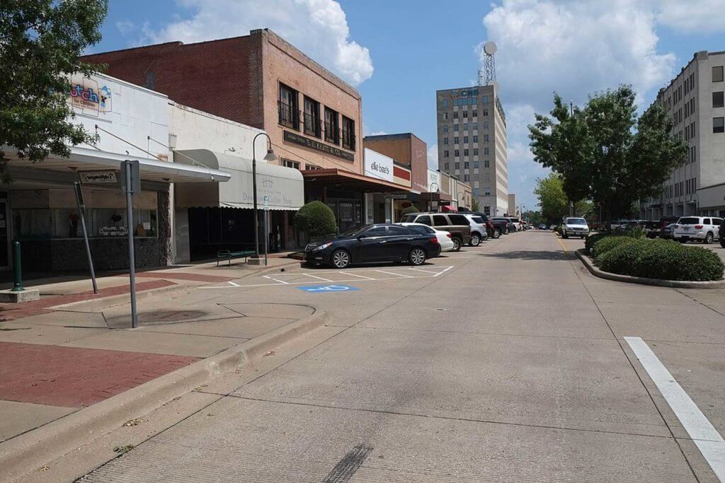 Cars are parked on a street in downtown Longview, Texas.