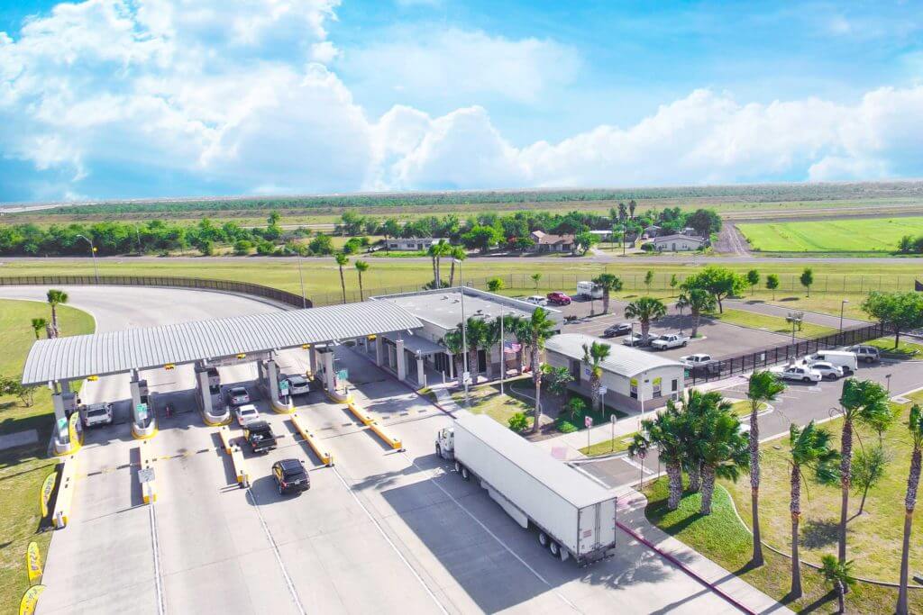 Cars and a truck pass through a toll on a highway in McAllen, Texas.