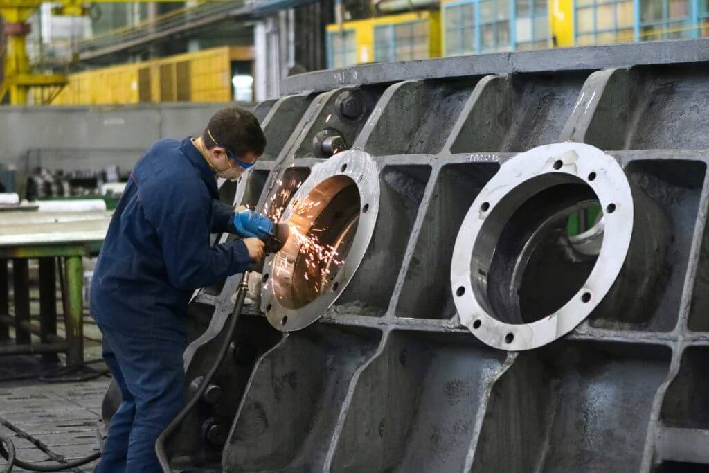 A man welds a round window frame