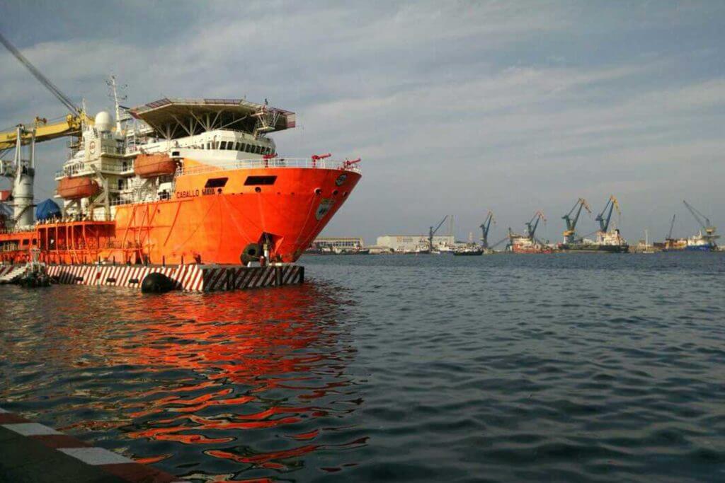 A large cargo ship moves through the ocean