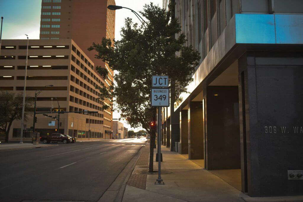 Downtown Midland features large office buildings and a road sign to direct drivers.