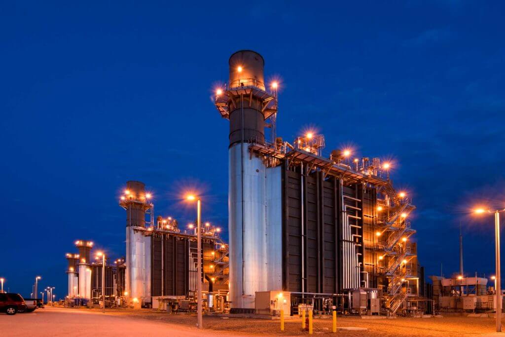 The Navasota Power Plant with large metal equipment lit up at night by lampposts