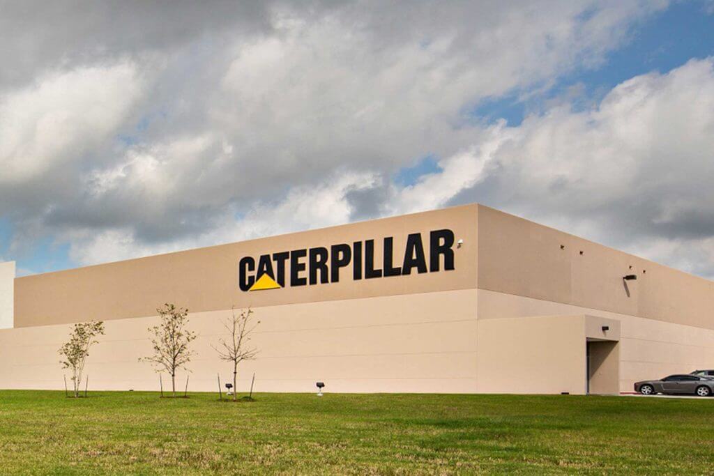 Exterior view of the beige concrete Caterpillar manufacturing facility in Victoria, Texas.