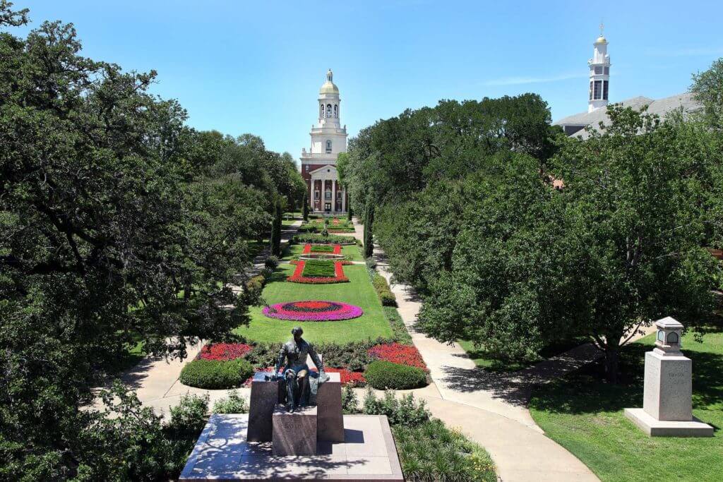 A green lawn with colorful flowers in front of Pat Neff Hall at Baylor University in Waco, Texas