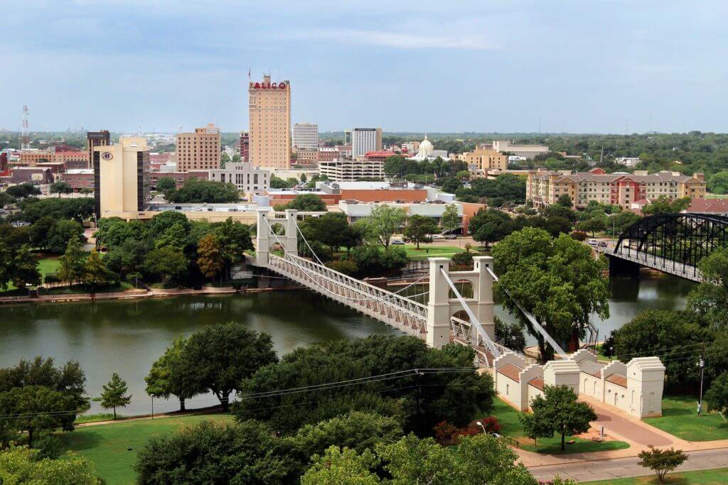 The Waco Suspension Bridge crosses the Brazos River in Waco, Texas.