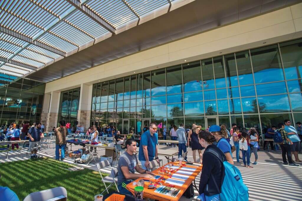 Groups gather at tables in an outdoor pavillion in Odessa, Texas.