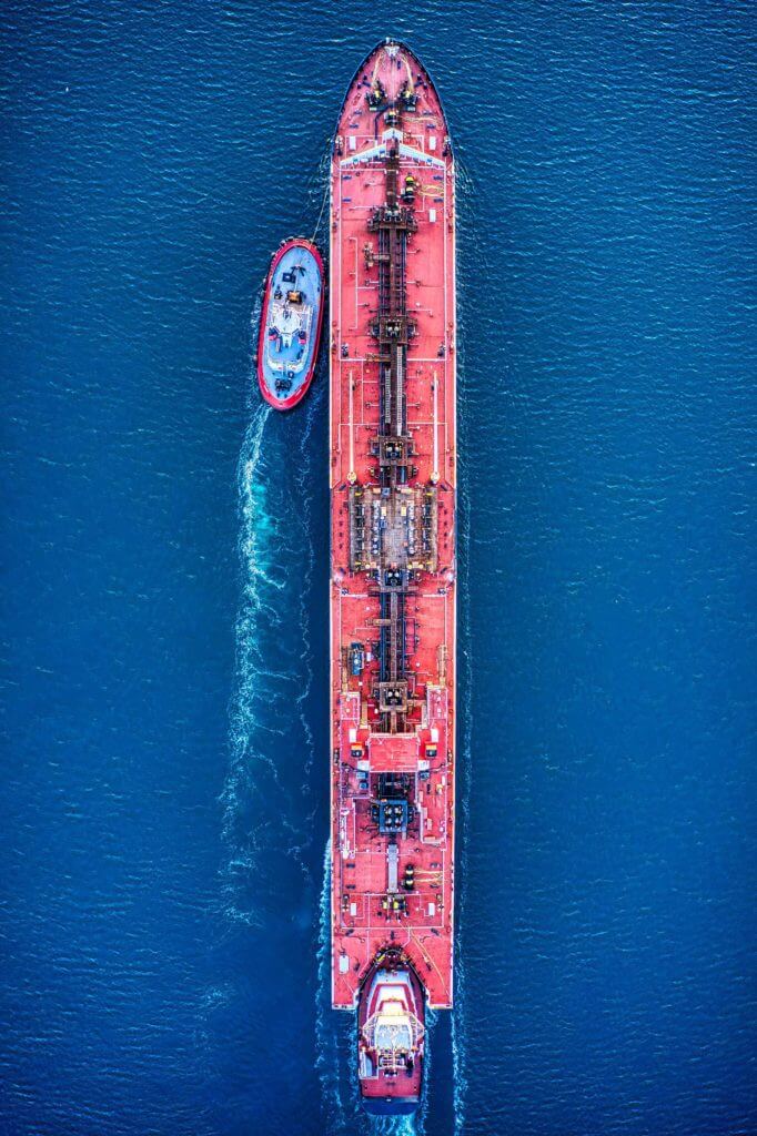 An aerial shot of a large cargo ship moving through the ocean