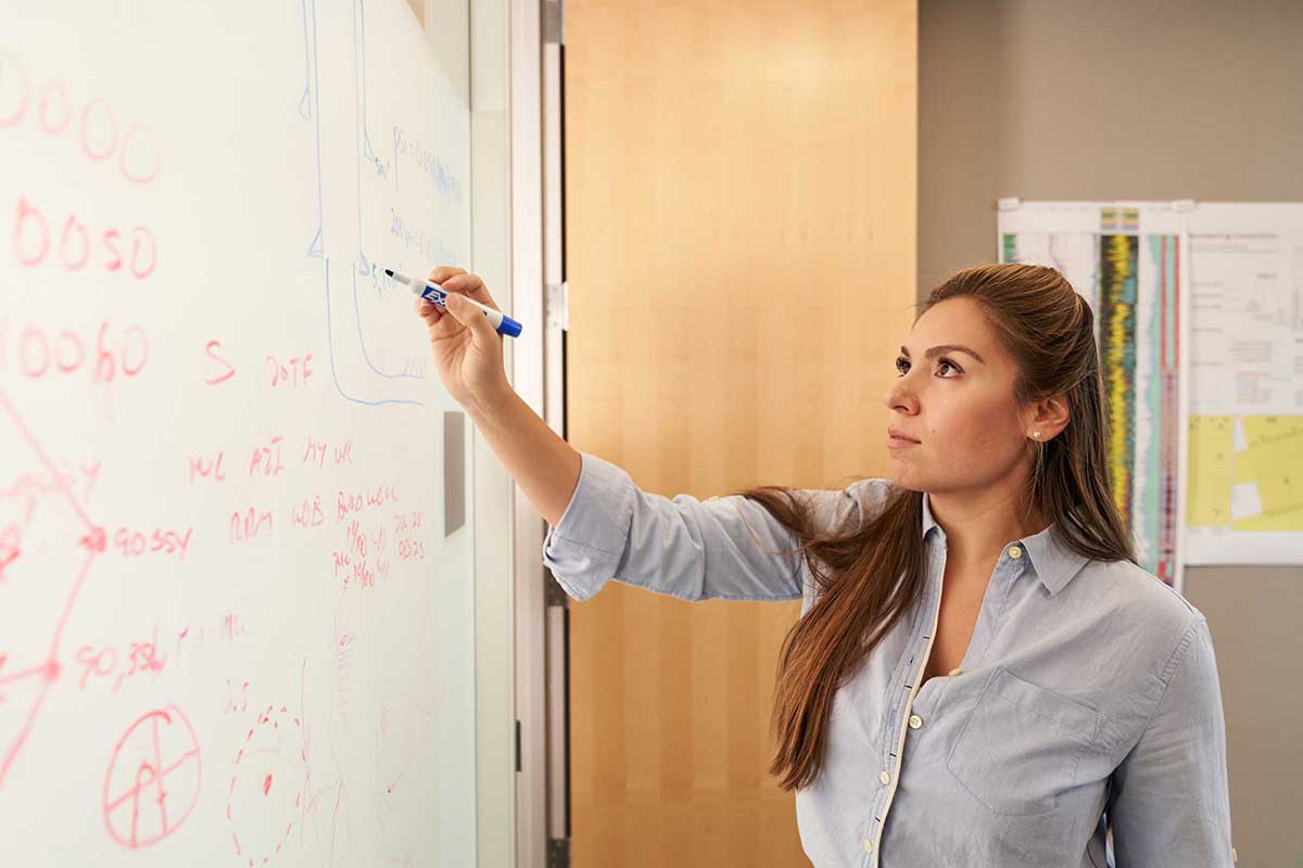Lady writing on a whiteboard in workplace in Texas