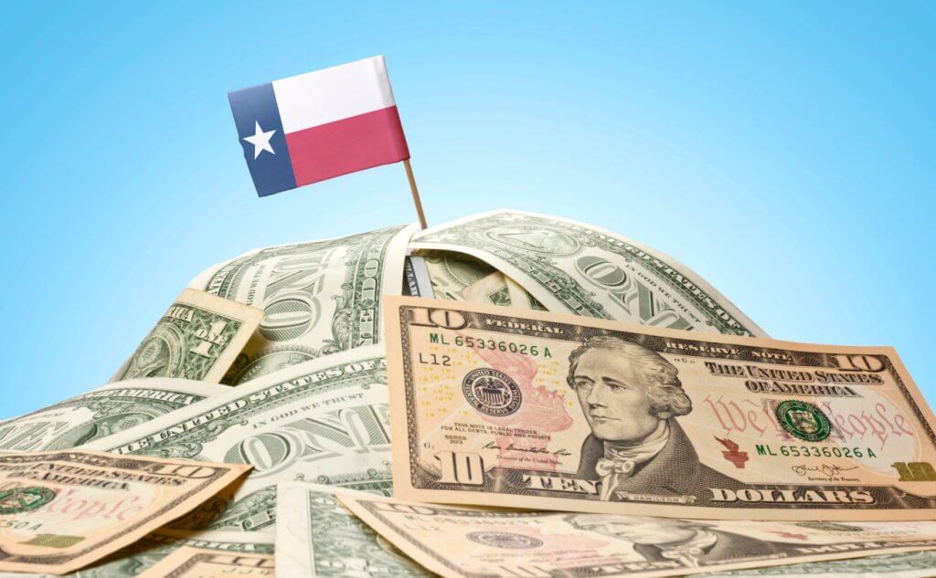 Flag of Texas planted in money demonstrating Texas's economic growth and strength