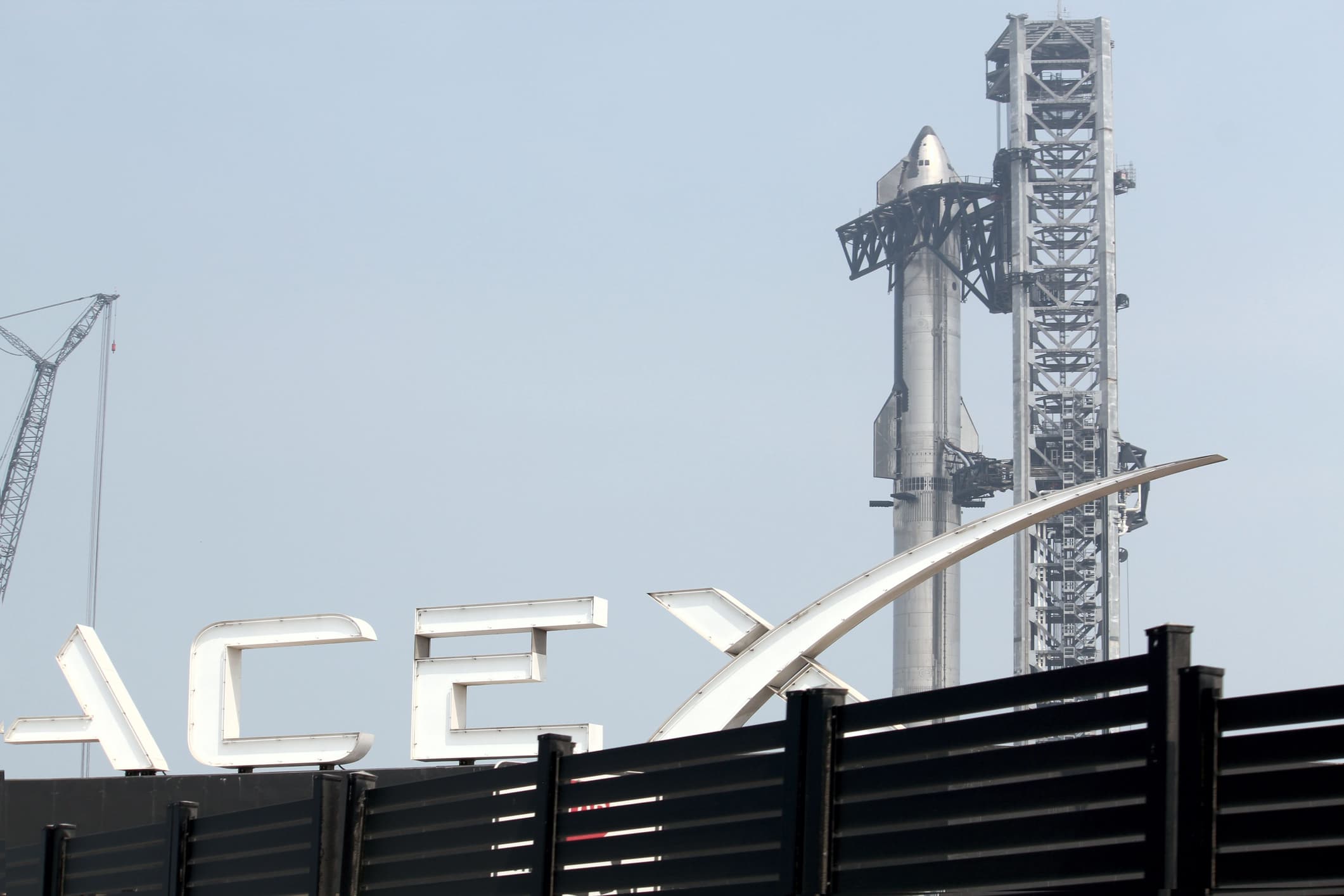 Starship and booster behind SpaceX sign on launchpad at Boca Chica launch complex in Boca Chica, Texas